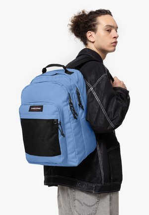 Mochila de nailon azul con múltiples compartimentos, bolsillo de malla frontal y acentos negros. Correas de hombro acolchadas para mayor comodidad.