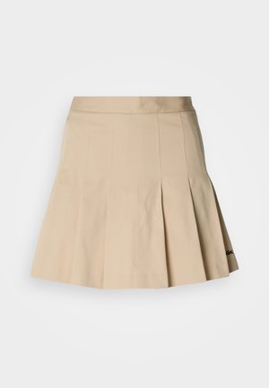 Falda plisada beige hecha de una mezcla de algodón. Presenta una cintura ajustada y un pequeño logo bordado en el dobladillo. Textura suave.