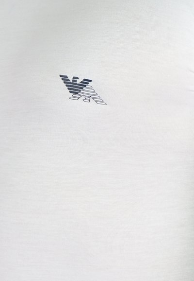 Weißes Baumwoll-T-Shirt mit einem blauen Logo. Der Stoff hat eine glatte Textur, mit einem taillierten Design und kurzen Ärmeln.