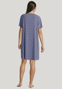 Camicia da notte viola a fantasia con maniche corte e vestibilità ampia, presenta un colletto rotondo e arriva fino al polpaccio. Tessuto morbido.