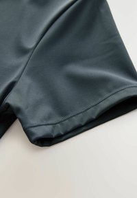 Ciemnoniebieskie spodenki sportowe wykonane z gładkiego, elastycznego materiału. Posiadają elastyczny pas i staranne przeszycia wzdłuż brzegu.