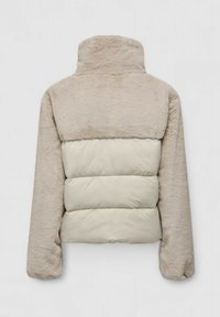 Polstret jakke i beige og krem, med en myk øverste del med høy krage og en vattert nederste del. Myk tekstur med lange ermer.