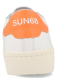 Sneaker bianco con una parte superiore testurizzata, logo arancione sul tallone e suola in gomma beige. Cuciture visibili lungo la suola.