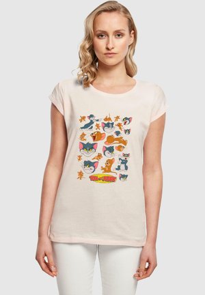 Helles rosa Baumwoll-T-Shirt mit einem Cartoon-Grafikdesign, das verschiedene Charaktere aus "Tom und Jerry" zeigt, zentriert unterhalb des Kragens. Kurze Ärmel.