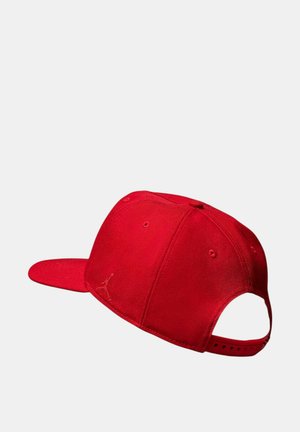 Gorra roja fabricada en tejido texturizado con visera plana, que presenta un pequeño logo en la parte frontal y una correa ajustable en la parte trasera.