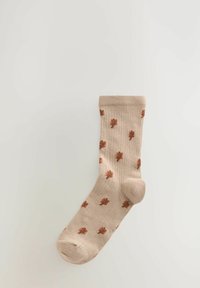 Beige cotton sock featuring a ribbed texture with small brown leaf patterns evenly spaced across the surface. Smooth toe and heel design.