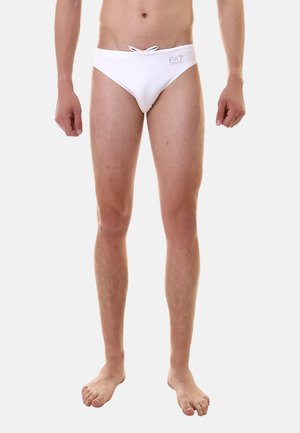 Slip da bagno bianchi con cordoncino in vita, texture liscia e logo stampato sul lato, progettati per attività acquatiche.