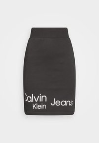 Mini gonna nera in jersey con vita aderente, caratterizzata da testo bianco "Calvin Klein Jeans" in diverse dimensioni di carattere lungo il bordo.