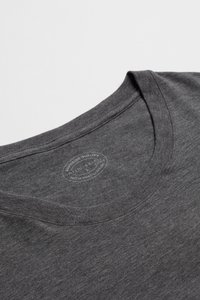 Szara koszulka z krótkim rękawem i okrągłym dekoltem, wykonana z miękkiego materiału, z delikatnym teksturowanym wzorem oraz słabym logo wewnątrz kołnierza.