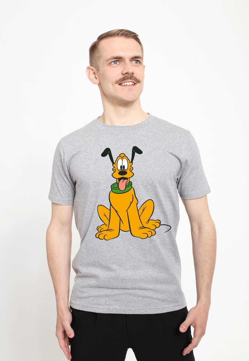 Camiseta de algodón gris con un gráfico de un perro de dibujos animados con un collar verde, representado en naranja y negro, sentado con la lengua afuera.