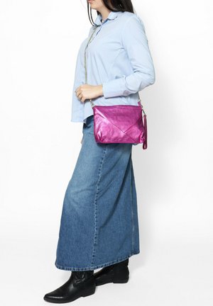 Sac bandoulière fuchsia avec une finition texturée, doté d'une fermeture zippée, d'une bandoulière en chaîne et d'éléments de design angulaires.