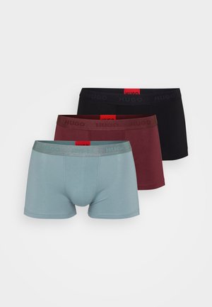 Tre par Hugo boxershorts i lyseblå, burgunder og sort. Hver har en elastisk talje med "HUGO" præget og et rødt mærke.