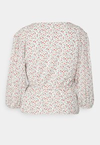 Blusa branca com um padrão floral em vermelho, azul e verde. Apresenta um design cruzado, mangas longas com volume e uma cintura ajustada.