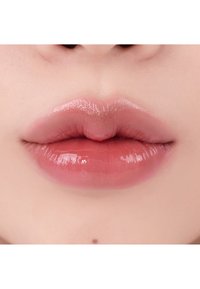 Glänzende, volle Lippen in einem sanften Rosa-Ton, mit einer glatten Textur und dezentem Glanz, die eine natürliche Form haben und ohne sichtbare Makeup-Akzente sind.