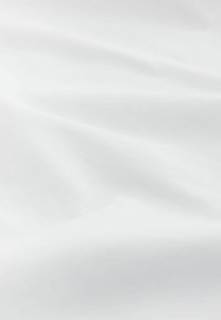 Material alb cu o textură netedă, mată, ce prezintă cute și pliuri subtile. Ușor și simplu în design, fără modele sau accente.