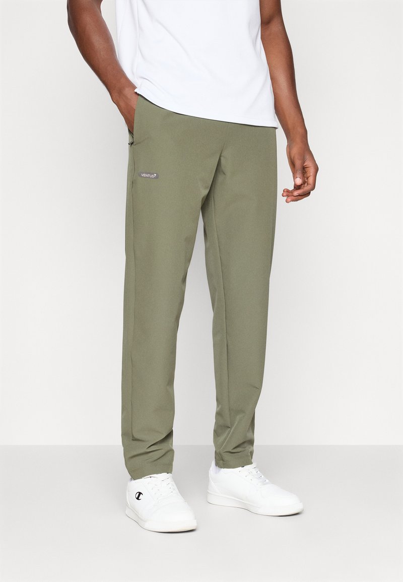Olive green trousers in a lightweight material, featuring a side pocket and a small "VENTUS7" logo. Paired with white sneakers.