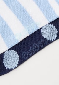 Modrá a biela pruhovaná látka prechádza do námorníckej časti s malými svetlomodrými bodkami, so soft knit textúrou a vyšitou logom.
