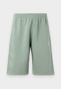 Πράσινα σορτς μέχρι το γόνατο φτιαγμένα από μαλακό ύφασμα με ελαστική μέση. Διαθέτουν πλαινές τσέπες και ένα μικρό λευκό λογότυπο στην κάτω αριστερή πλευρά.