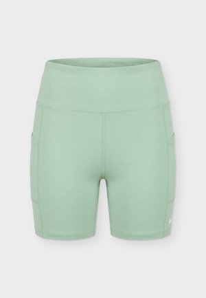 Hele-rohelised kõrge vöökohaga spordipüksid küljetaskute ja nähtavate õmblustega, loodud mugavuseks ja aktiivseks kandmiseks.