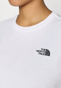 Λευκό κοντομάνικο t-shirt με στρογγυλή λαιμόκοψη και μαύρο κεντημένο λογότυπο στο στήθος με το κείμενο "The North Face" και σχεδιασμό σε τόξο.