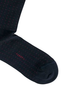 Calze navy con piccoli pois rossi, realizzate in un materiale morbido, con punta rinforzata e logo stampato in rosso vicino alla caviglia.