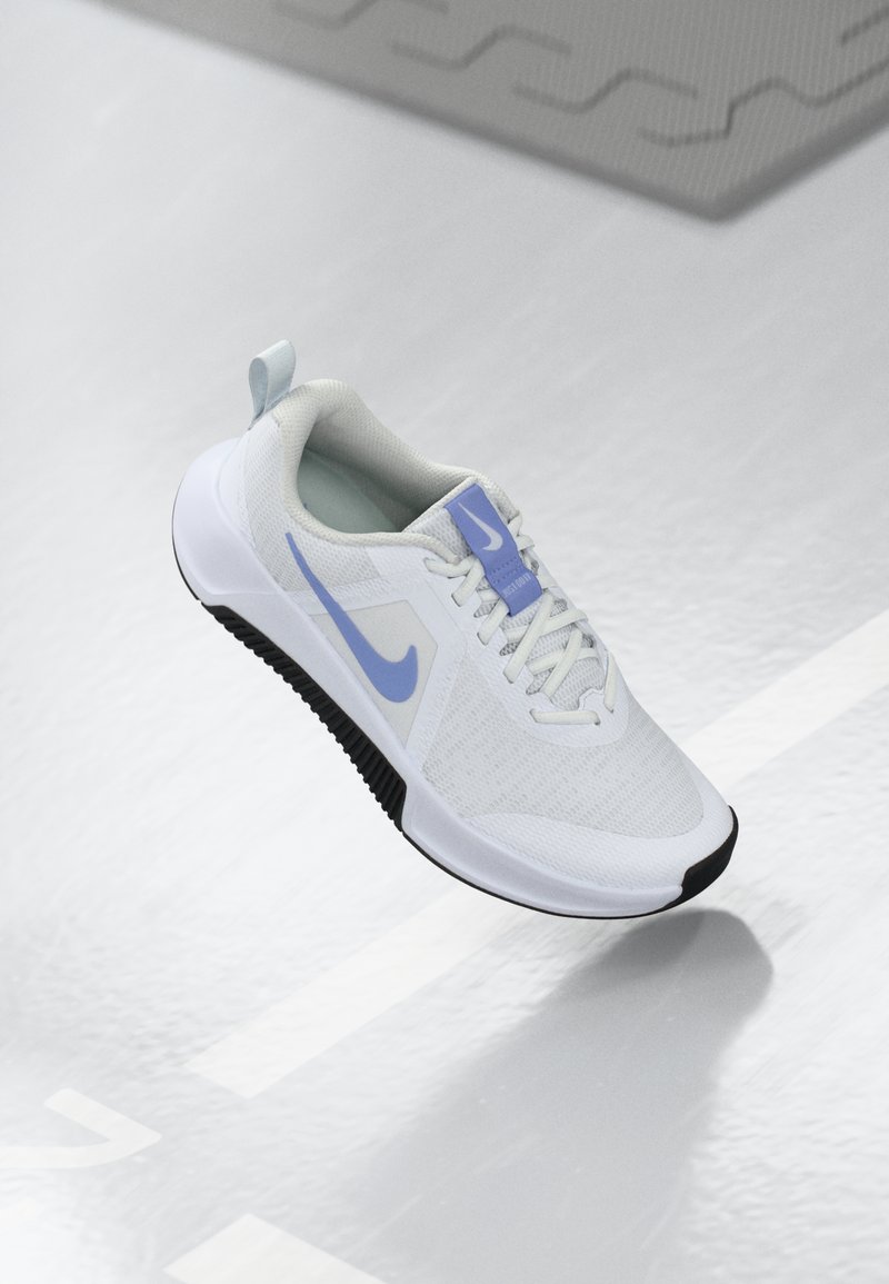 Hvit treningSko med et lett mesh-overdel, med en lyseblå Nike-logo og en svart gummisåle med teksturert mønster.