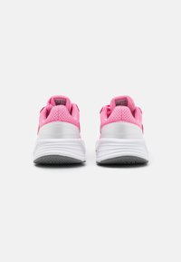 Różowe siatkowe buty sportowe z białymi gumowymi podeszwami, zaokrąglonymi obcasami oraz teksturowanym wzorem na cholewce. Posiadają wyściółkowane kołnierze i sznurowanie.