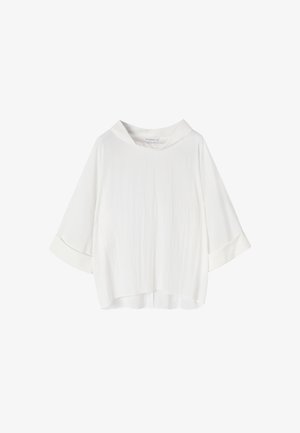 Laisvas baltas ilgomis rankovėmis bluzonas su plačiais manžetais ir minkštu, krentamu apvaliu kaklu.