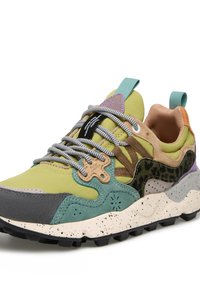 Baskets multicolores avec un mélange de matériaux, comprenant des accents verts, gris et bruns. Présente des textures variées, des côtés à motifs et une semelle mouchetée.