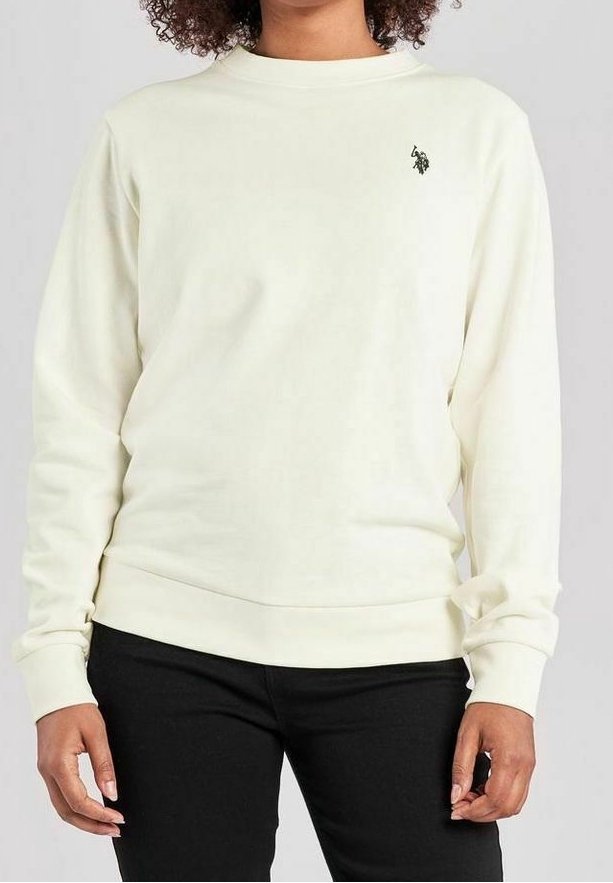 Personne portant un sweat-shirt à manches longues de couleur blanc cassé avec un petit logo noir sur la poitrine gauche et un pantalon noir.