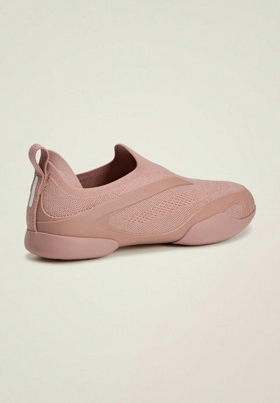 Zapato rosa tipo slip-on de tela de punto texturizada. Cuenta con suela acolchada, punta redondeada y una lengüeta en el talón.