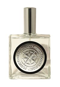 Heldere glazen rechthoekige fles met een zilveren dop, voorzien van een zwarte ronde label met een reliëf ontwerp van een zilveren kompas en tekst.