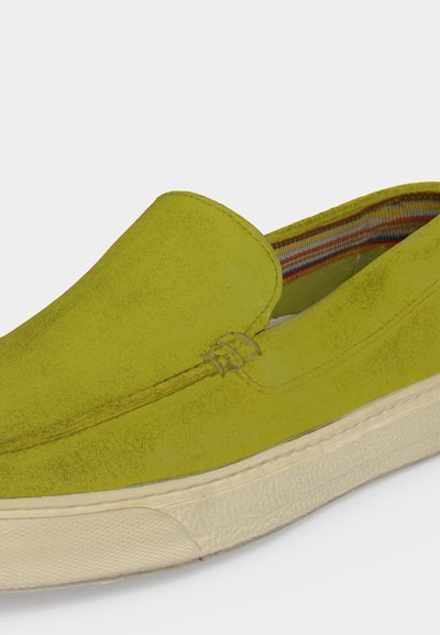 Κίτρινο σχέδιο slip-on από σουέντ με λευκή υφή ελαστική σόλα και ριγέ υφασμάτινη επένδυση στο εσωτερικό.