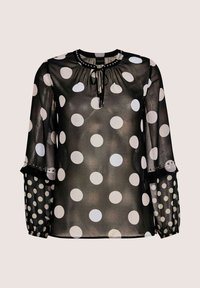 Schwarze transparente Bluse mit großen weißen Punkten, langen Ärmeln mit kleineren Punkten, gerafftem Ausschnitt und Schlüsselbogen-Bindeschluss.