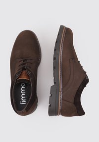 Zapatos de cuero marrón con una superficie texturizada, que presentan cordones, una plantilla acolchada y una suela de goma resistente con un ribete en contraste.