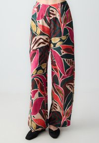 Pantaloni a gamba larga con un motivo floreale colorato, che presenta tonalità di rosa, verde e oro su uno sfondo scuro, tessuto testurizzato e tasche laterali.