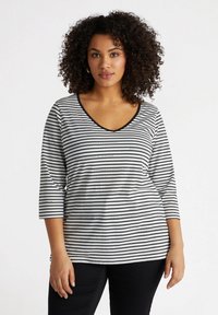 Svart-vitrandig, löst sittande topp med v-ringning och trekvartslånga ärmar. Mjuk bomullsblandning med subtila prickiga accentuer.