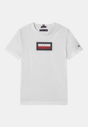 Biała bawełniana koszulka z krótkim rękawem, z okrągłym dekoltem. Na koszulce znajduje się prostokątny logo w kolorach czarnym, czerwonym i białym oraz akcent przy rękawie.