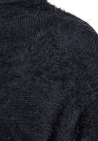 Donker marineblauwe gebreide trui met een gestructureerde, fuzzy afwerking, met een hoge halslijn en een ontspannen, losse weefpatroon.