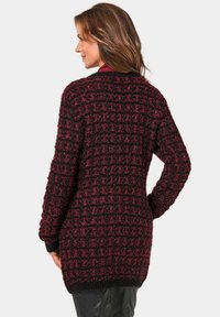 Strickjacke in Dunkelrot und Schwarz mit einem strukturierten Checkmuster, langen Ärmeln und lockerer Passform, ausgestattet mit einem gerippten Saum und Bündchen.