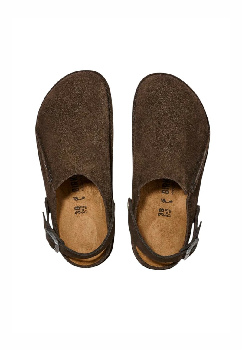 Zoccoli in suede marrone con punta aperta, cinturino sul retro e soletta testurizzata. Taglia 38 segnata all'interno, dotati di un fregio in metallo.