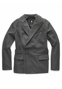 Kaksirivinen harmaa bleiseri, joka on valmistettu teksturoidusta kankaasta. Siinä on leveät kaulukset, kaksi etutaskua ja rintatasku, jossa on logoyksityiskohta.