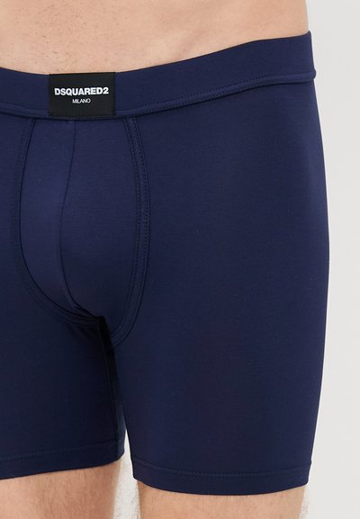 Σκούρο μπλε σλιπάκια φτιαγμένα από ελαστικό ύφασμα. Διαθέτουν ελαστική μέση με ετικέτα DSQUARED2, στενή εφαρμογή και χωρίς ραφές κατασκευή.