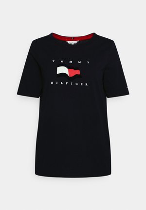 Námořnicko modré bavlněné tričko s krátkým rukávem, na kterém je bílé logo "TOMMY HILFIGER" a design vlajky v bílé, červené a černé barvě.