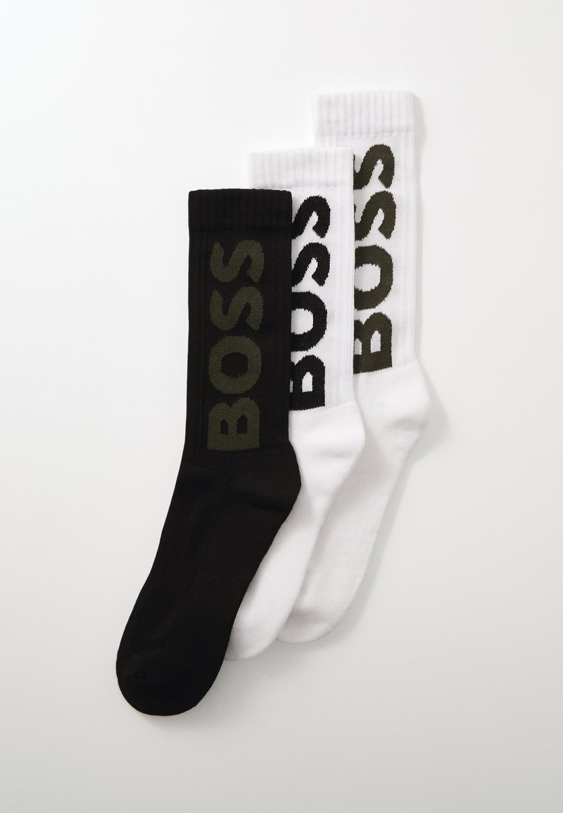 Trois paires de chaussettes : une noire avec le logo "BOSS" vert, une blanche avec le logo "BOSS" vert foncé, texturé en côte, longueur mi-mollet.