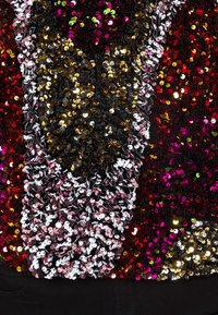 Top di paillettes con un design multicolore che presenta paillettes rosse, rosa, nere e dorate di diverse dimensioni. Superficie testurizzata e scintillante.