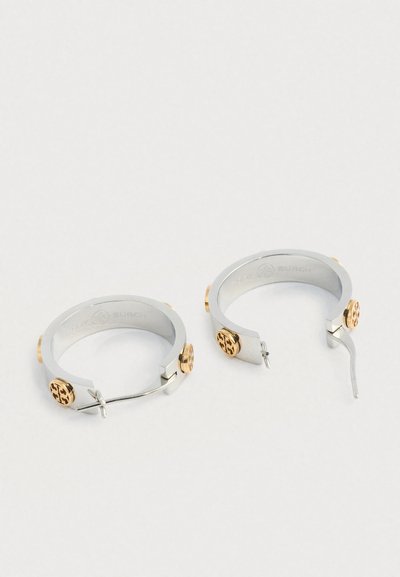 Ασημένιες κρίκοι σκουλαρίκια με χρυσές λεπτομέρειες, διαθέτοντας λεία επιφάνεια και ασφαλές κούμπωμα. Κάθε σκουλαρίκι διαθέτει λεπτομέρεια με το λογότυπο.