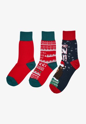 Kolmepakk sokke: ühevärvilised punased, punased pidulike mustritega ja tumesinine sokk, millel on karu Jõuluvanaga. Valmistatud pehmest kangast.