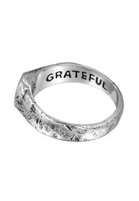 Silverring med en texturerad, vriden design. Graverad med ordet "TACKSAM" inuti. Slät yta med varierande mönster.