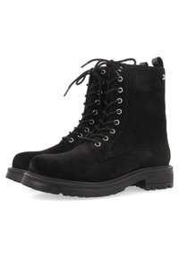 Stivali neri in suede con lacci, punta rotonda, occhielli in argento, suola piatta in gomma e tirante sul retro per facilitarne l'indossamento.